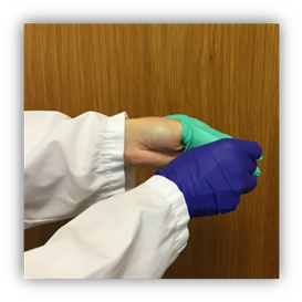 Gloved right hand is pulling the glove off the left hand and the glove is turning inside out.