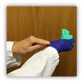 Fingers of the glove-less left hand slip under the glove of the right hand at the wrist. Gloved hand is holding the removed 1st glove.