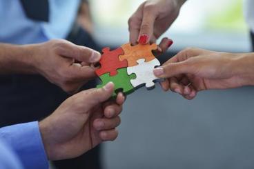Team members holding interlocking pieces of a puzzle